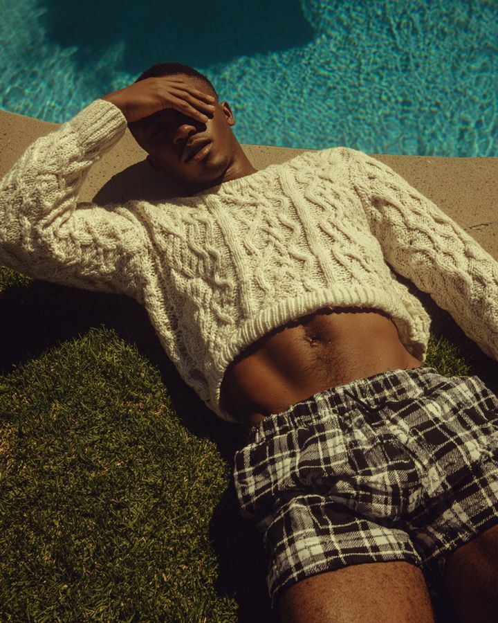 A man in a knitted top lying on grass