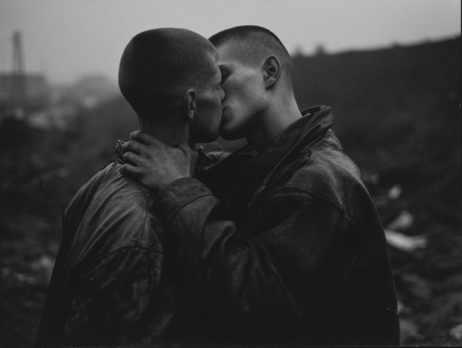 Two men embracing in a landscape, in black and white