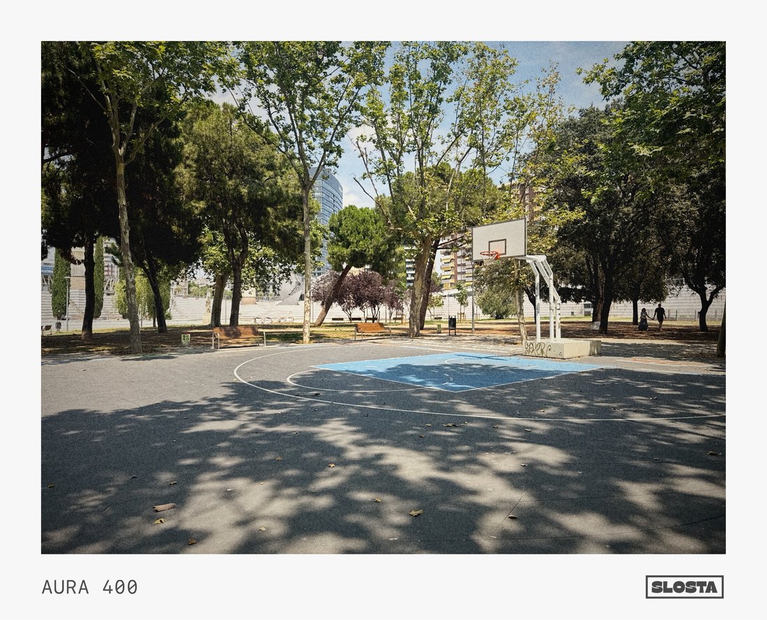 A basketball court shaded by trees, framed with SloSta's AURA 400 film stock