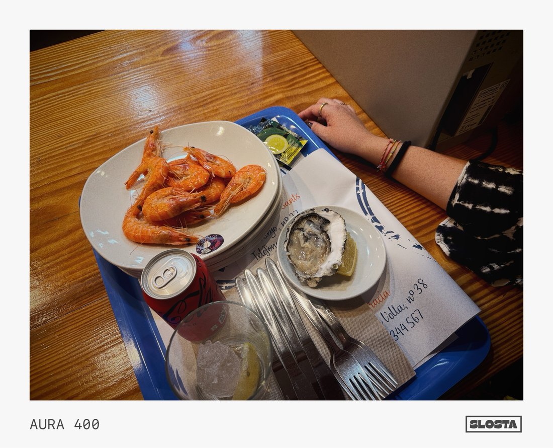 A plate of fried shrimp and sides at a restaurant table, framed with SloSta's AURA 400 film stock
